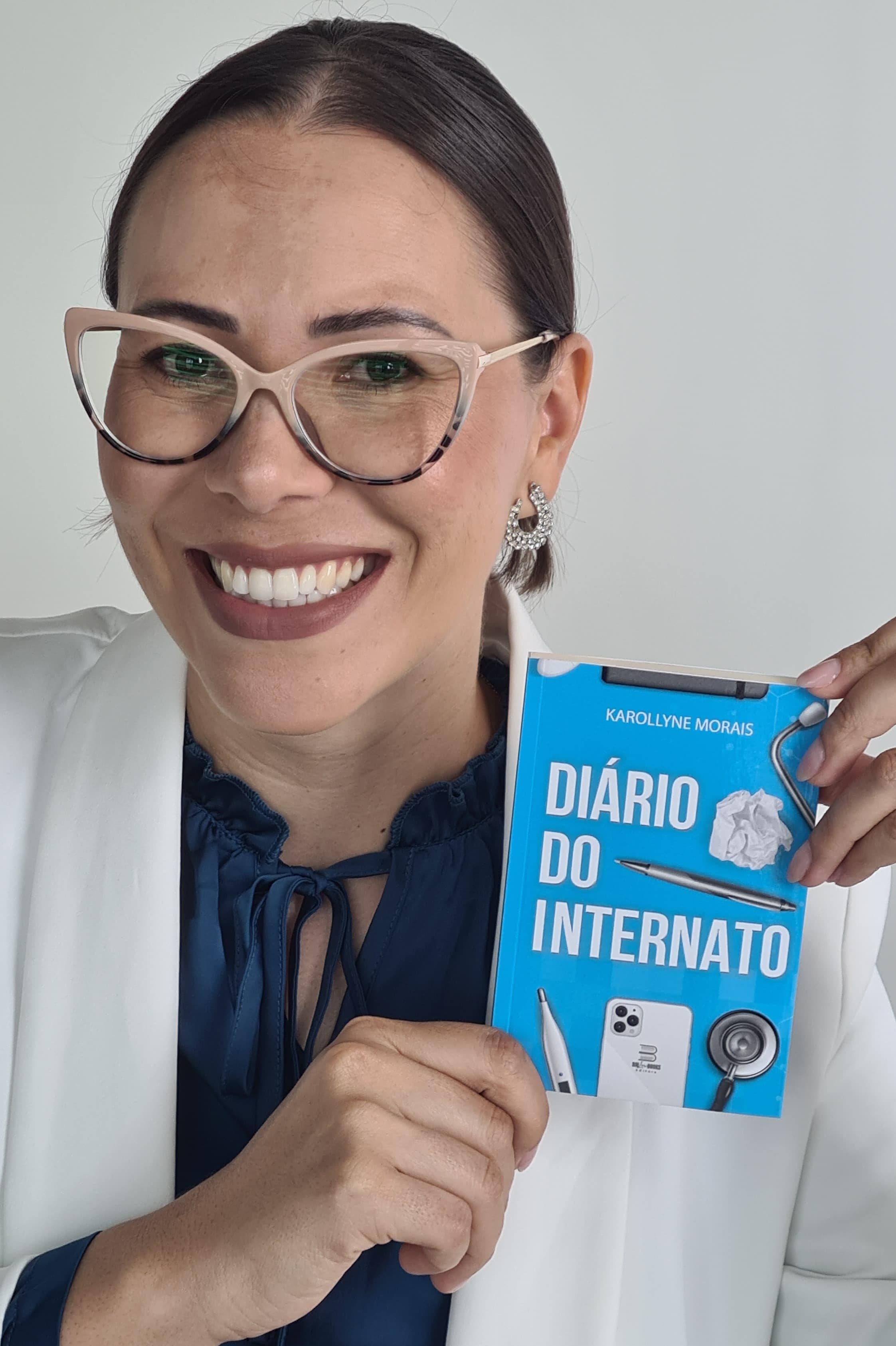 Dra. Karollyne Morais segurando o livro Diário do Internato